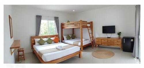 a bedroom with two bunk beds and a television at Vapanakhaw Ubon in Ubon Ratchathani