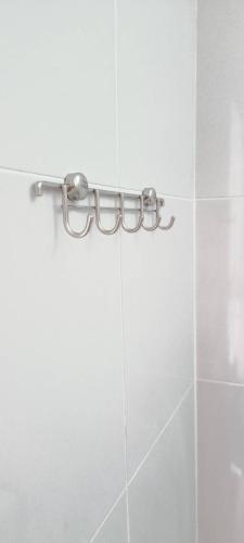 a towel rack in a white tiled bathroom at Vaplanakhaw Ubon in Ubon Ratchathani
