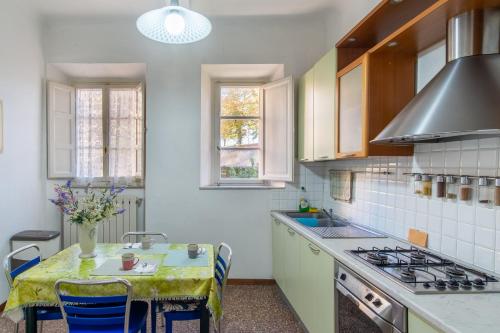 eine Küche mit Tisch und Herd oberen Backofen in der Unterkunft La chiave del tempo in Lucca