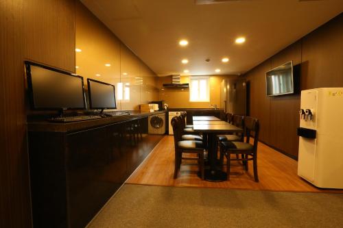 a kitchen with a table with chairs and a refrigerator at Tripstay Myeongdong in Seoul
