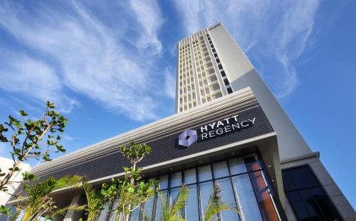 a building with a tall building in the background at Hyatt Regency Naha, Okinawa in Naha