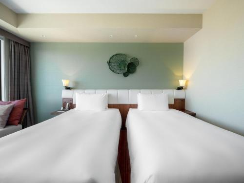 a room with two beds and a couch at Hyatt Regency Naha, Okinawa in Naha