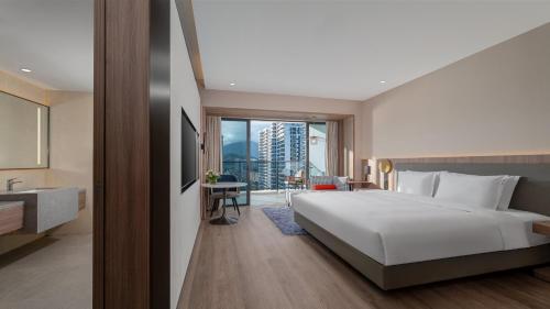 een slaapkamer met een groot wit bed en een balkon bij Holiday Inn Express Jiangmen Yinhu Bay by IHG in Jiangmen