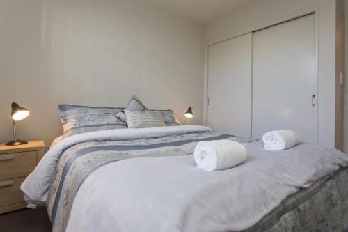 a bedroom with a bed with two towels on it at The Strandon - loft style central apartment in New Plymouth