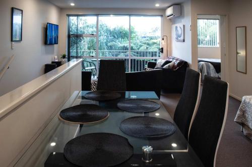 a room with a table and chairs and a living room at The Strandon - loft style central apartment in New Plymouth