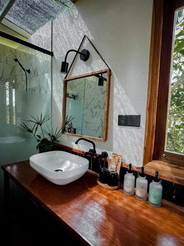 a bathroom with a sink and a mirror on a wooden counter at Nam garden lodge in Tân Phú