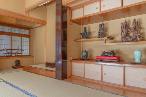 a room with wooden cabinets and shelves with vases at BANRYU 萬龍 バンリュウ in Iida