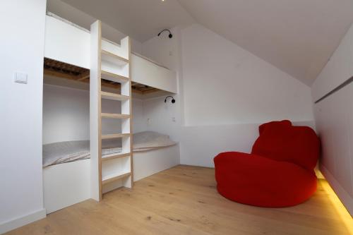 a red chair sitting in a room with bunk beds at Stay in Ghent in Ghent