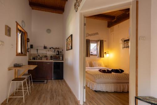 a bedroom with a bed and a small kitchen at ליבי במדבר מרחב לאקולוגיה של הריפוי Libi Bamidbar The Ecology of Healing Resort in Neʼot HaKikar