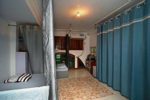 a bedroom with a bed and blue curtains in a room at Sakurahad Sai Gon Hostel in Kon Rung (1)