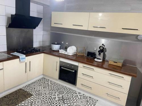 una cucina con mobili bianchi e un piano di lavoro di La kazolie a Sainte-Rose