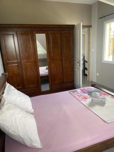 a bedroom with a pink bed with a mirror at La kazolie in Sainte-Rose