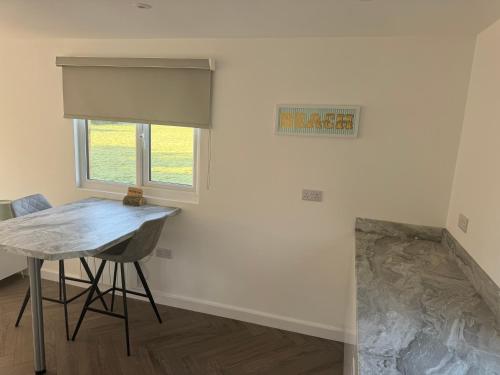 a dining room with a table and a window at Luxury Beachfront Lodge in Hest Bank