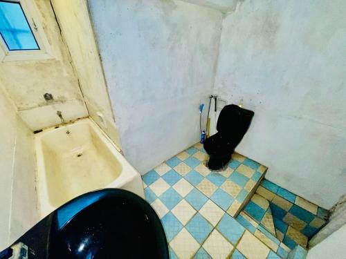 a bathroom with a black toilet and a sink at Michelles at Peradeniya Kandy in Kiribatkumbura