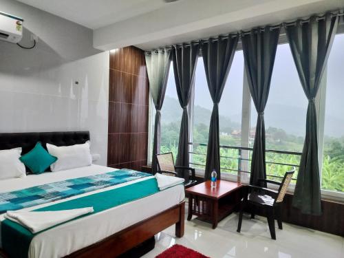 a bedroom with a bed and a large window at Chill Breeze Paradise in Yelagiri