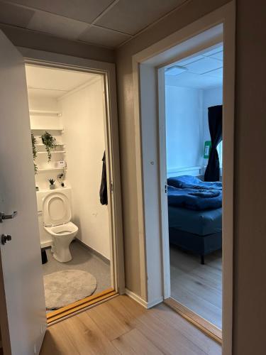 une salle de bain avec WC et une chambre avec un lit dans l'établissement Kirkenes town apartments, à Kirkenes
