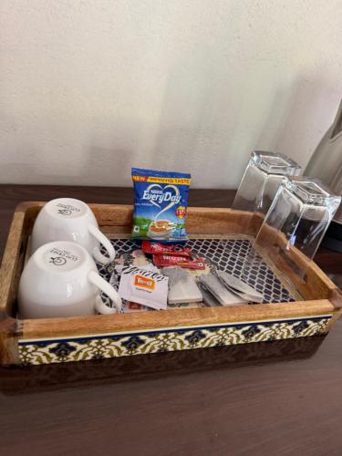a wooden tray with a tea set and a tea pot at Vin's Villa & caffe in Bīr