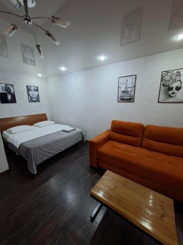 ein Wohnzimmer mit einer Couch und einem Bett in der Unterkunft Квартира с видом на парк,в минуте ходьбы от Акимата,Налоговой, Прокуратуры,Рахмета,Dostyk Mall,ЦОНа in Petropawlowsk