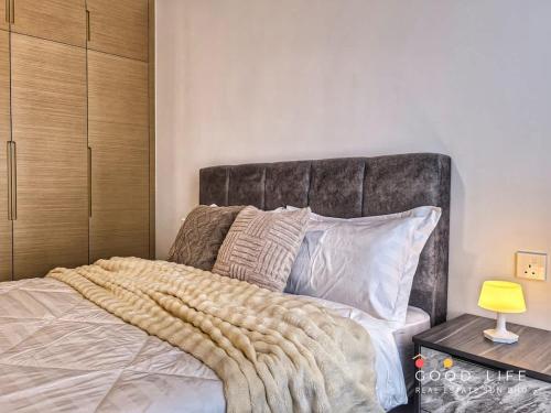 a bedroom with a bed with a large headboard at Queen Room R&F Princess Cove Shared Common Space in Johor Bahru