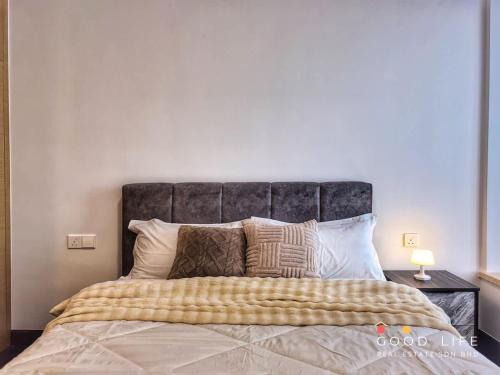 a bedroom with a large bed with a gray headboard at Queen Room R&F Princess Cove Shared Common Space in Johor Bahru