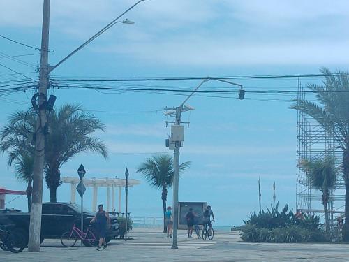 eine Gruppe von Menschen, die am Strand spazieren gehen und Fahrrad fahren in der Unterkunft Acampamento Aloha solemar in Praia Grande