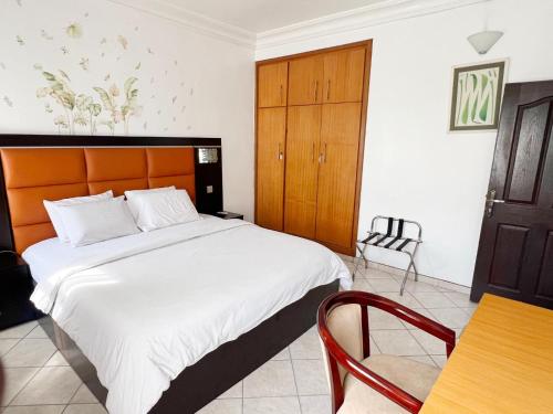 a bedroom with a large bed and a table and chairs at Cata Apartment Hotel And Spa in Ikeja