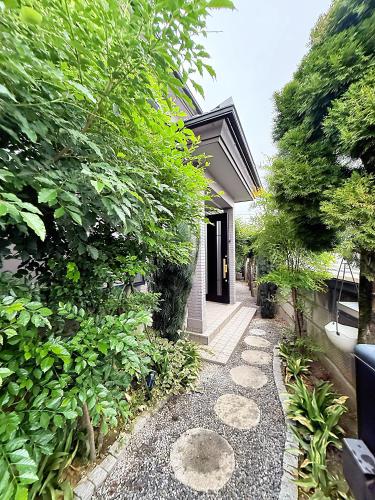 a garden path leading to a house with trees at Sky House in Kawagoe