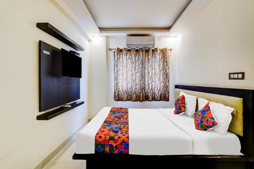 a bedroom with a white bed and a television at Via Royal Regalia Inn - Jayanagar in Bangalore