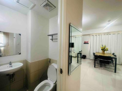 een badkamer met een toilet, een wastafel en een tafel bij Spacious Central Davao City Getaway - Spacious Apartment with Shared Pool in Cabaguio