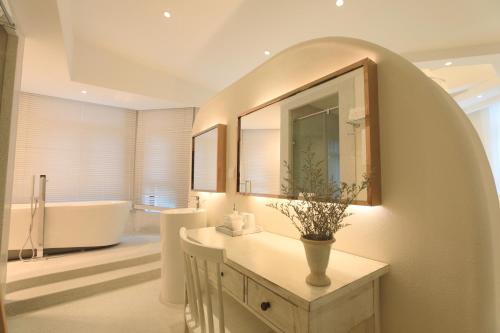 a bathroom with a sink and a bath tub at Hando • Cape Seven Seaside Villa in Qingdao