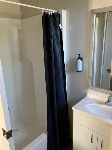 een badkamer met een zwart douchegordijn naast een wastafel bij Major Mitchell Caravan Park in Mitchell
