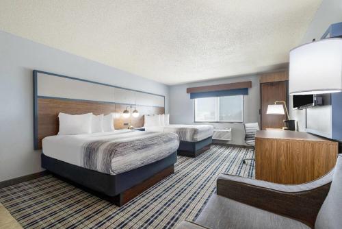 a hotel room with a large bed and a bathroom at AmericInn by Wyndham Chamberlain Conference Center in Chamberlain