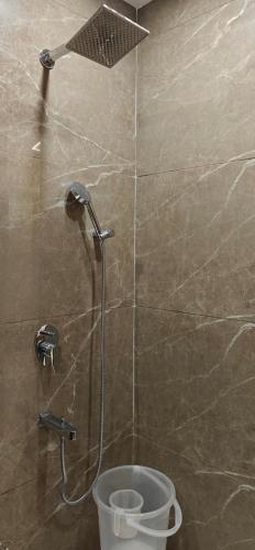 a shower in a bathroom with a bucket at Hotel Ivaan Homes opposite to Iskcon Temple East of Kailash New Delhi in New Delhi