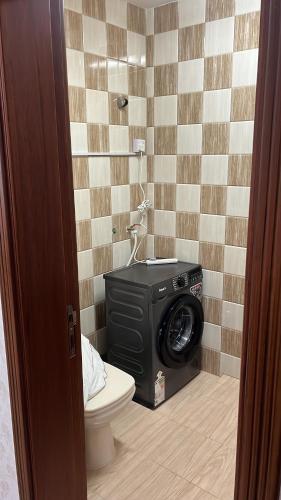 a bathroom with a washing machine and a toilet at Moon hostel in Seeb