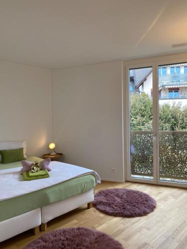 a bedroom with a bed and a large window at Modern 3-room apartment in Kloten