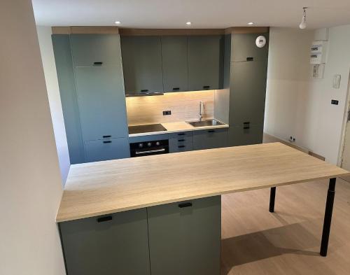 a large kitchen with a wooden counter top at Charmant appartement aux portes de Strasbourg in Oberhausbergen