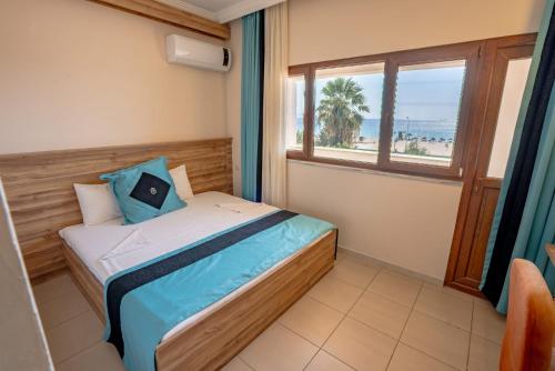 a bedroom with a bed with a view of the beach at Buyuk Berk Hotel in Ayvalık