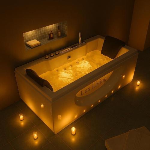 a bathroom with a large tub with lights in it at Lux Living Hotel in Bangalore