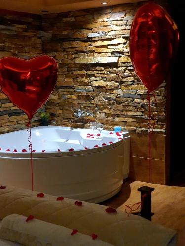 a bath tub with a heart balloon in a room at Stone Spa Apartman in Sremčica