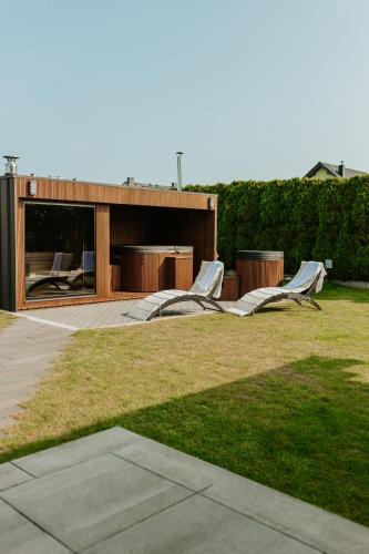 a house with two slides in the grass at Dom Marina Mosty, Sauna Hot Tub Holiday Home near Rewa Gdańsk in Mosty