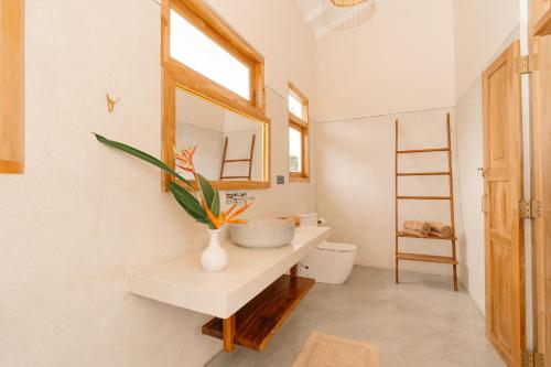 ein Badezimmer mit Waschbecken, Toilette und Spiegel in der Unterkunft Oura Spirit in Unawatuna