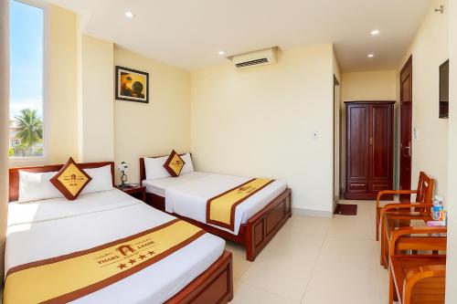 een hotelkamer met twee bedden en een tafel bij Thăng Long Hotel Thanh Hoá in Thanh Hóa