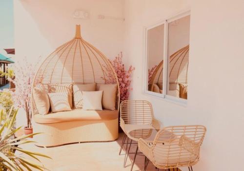 ein Zimmer mit einem Rattansessel und einer Couch in der Unterkunft Parasio de Bernal Beach Resort in Cabangan