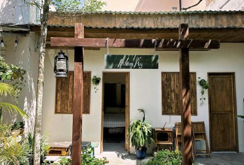 une maison avec un panneau en bois devant dans l'établissement Năm Ấy Homestay, à Phan Thiết