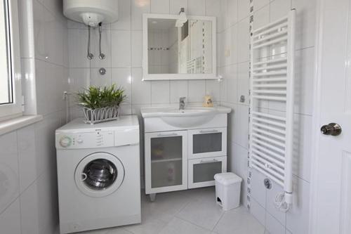 a white bathroom with a washing machine and a sink at Apartment Vanja in Tučepi