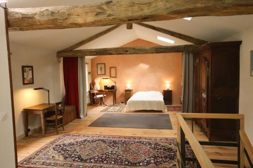 an attic bedroom with a bed and a desk at Le Refuge de Bruno in Saint-Amans-Soult