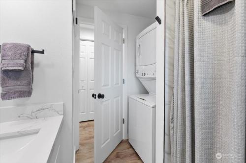 a white bathroom with a sink and a mirror at Luxury A-Frame with Hot Tub, Fireplace & Firepit in Skykomish