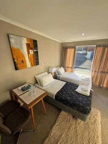 a hotel room with two beds and a table at Casa Miguelle a Private 1br mini house in Dunedin