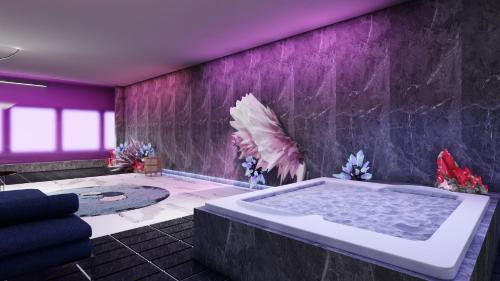 een paarse badkamer met een groot bad bij Papagei Cosy Home in Staßfurt