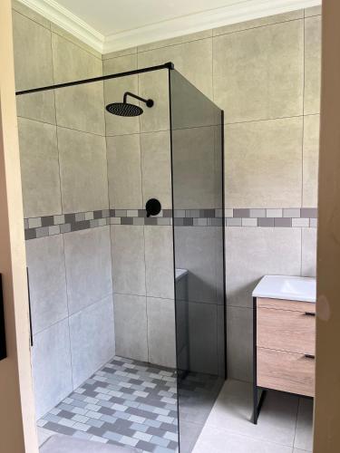 a shower with a glass door next to a sink at CozyNest in Margate